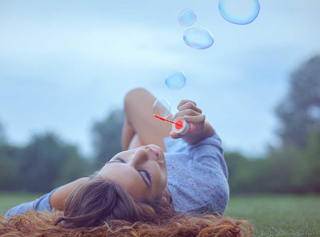 jong vrouw blaast zeepbellen